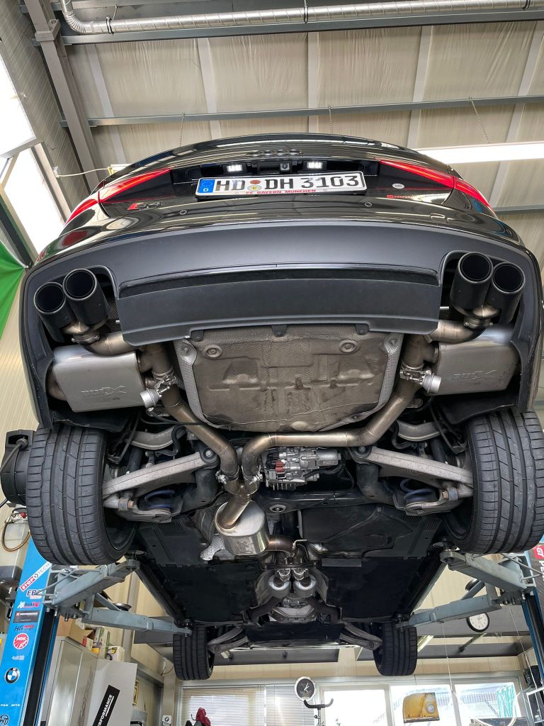 Aufgebocktes Auto in Werkstatt mit Auspuffanlage