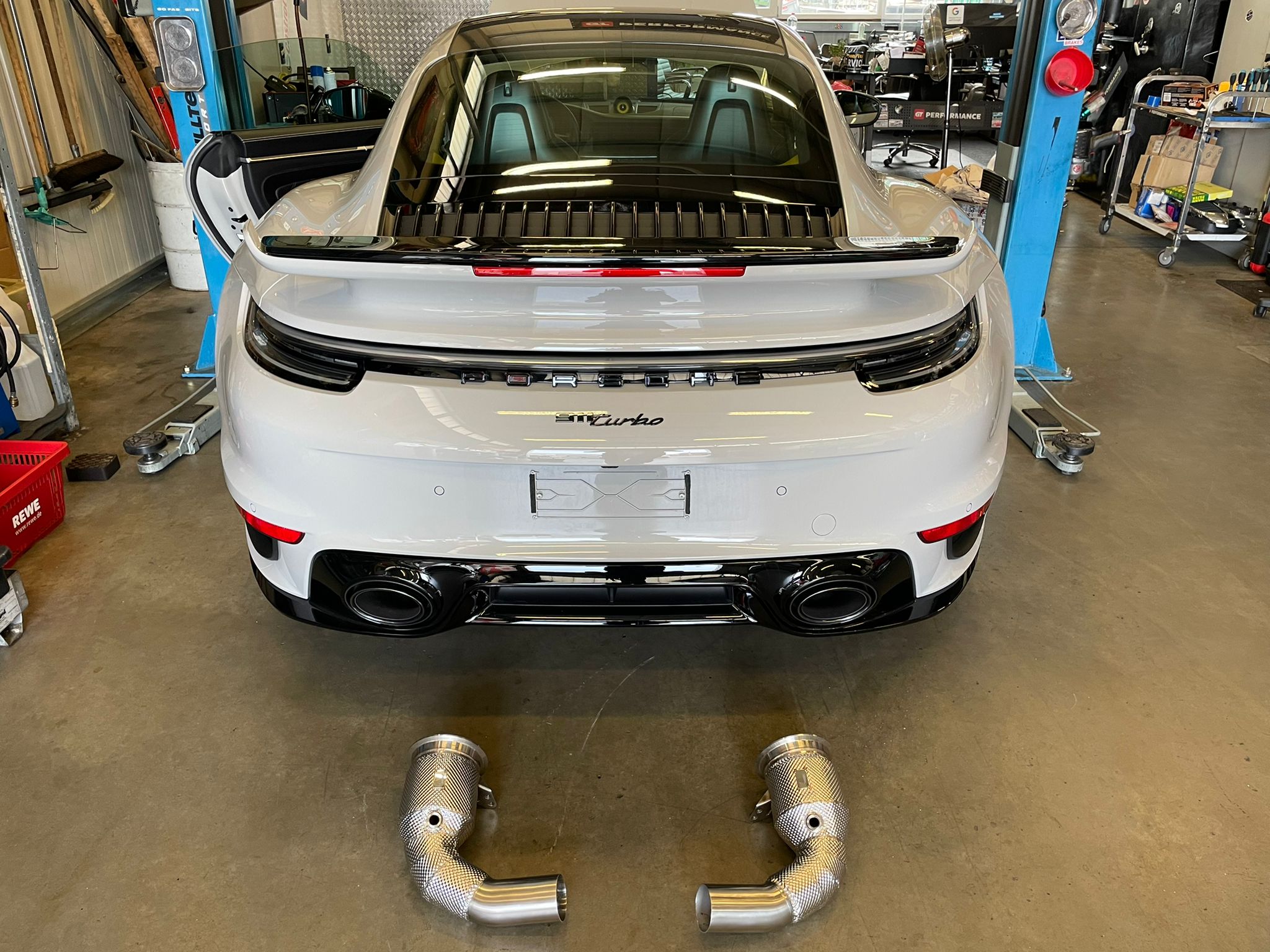 weißer Porsche in der Werkstatt mit neuer Abgasanlage