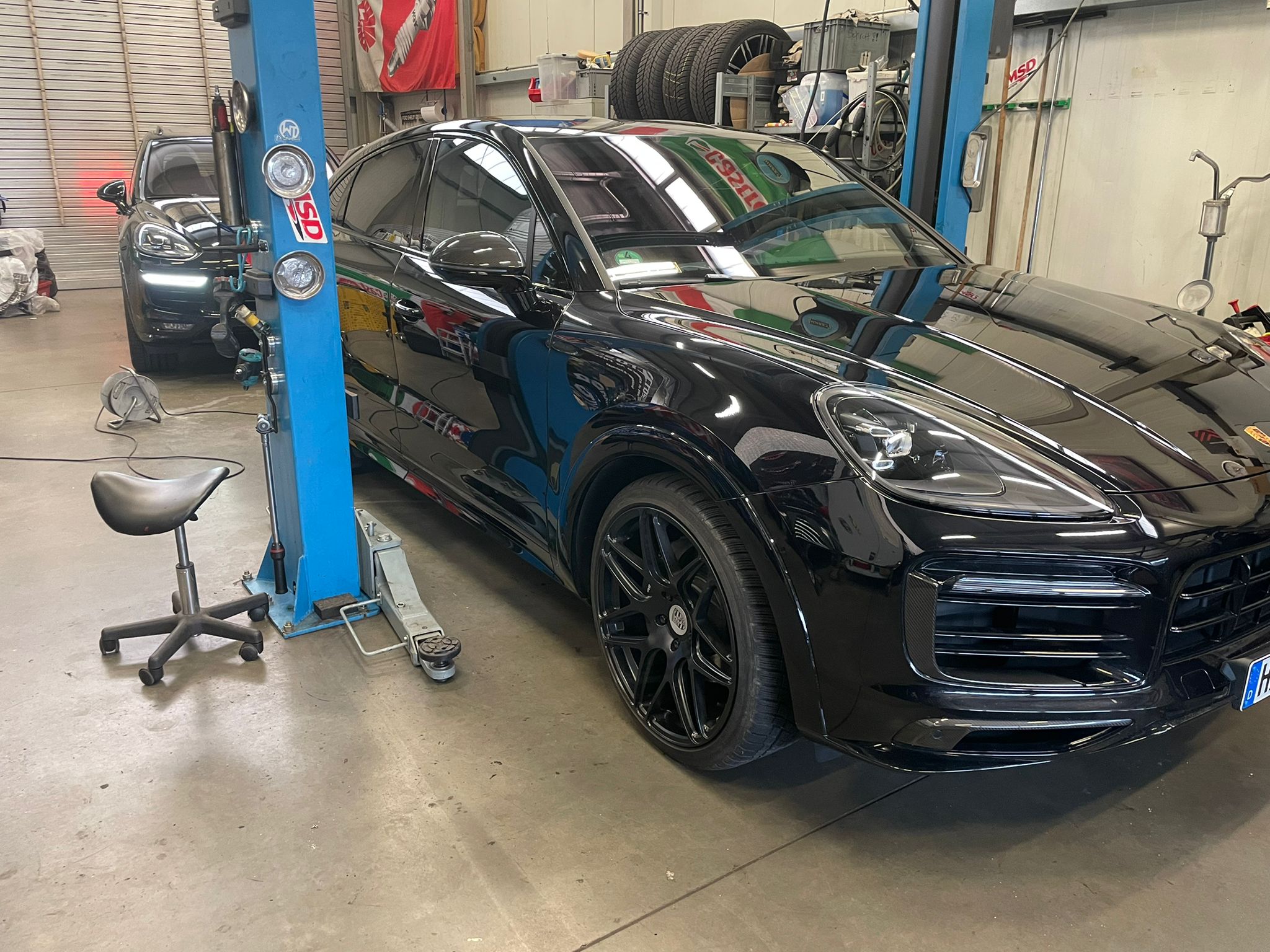 schwarzer Porsche beim Tuning in Werkstatt